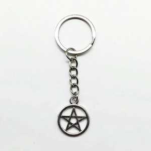 Vintage silver peace sign keychain with star pendant and metal ring on white background