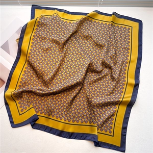 Detail of a 70cm square silk scarf featuring yellow and navy blue geometric patterns