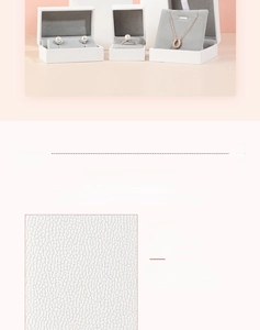 Detailed view of white faux leather jewelry boxes with grey velvet lining for rings and necklaces