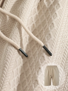 Detail of beige waffle knit texture and drawstring waist on men's casual shorts