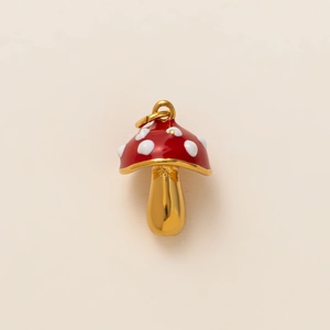 Macro view of a 18k gold-plated mushroom pendant with red enamel and white spots