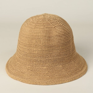 Gros plan d'un chapeau de soleil en maille beige montrant la texture tissée détaillée
