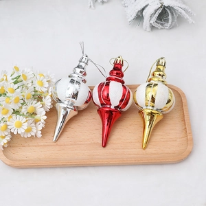 Drei Weihnachtshänger in Tropfenform in Gold, Rot und Silber auf einem Holztablett