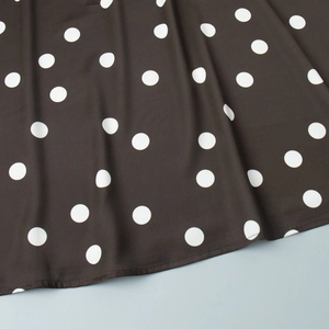 Détail macro du tissu à pois noirs montrant des coutures et une texture de qualité
