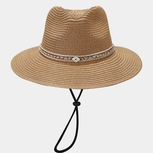 Detail of woven straw fedora featuring ethnic band and shell charm with chin strap