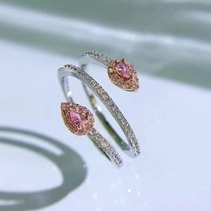 Detailed view of silver snake ring featuring rose gold heads and sparkling pink gemstones