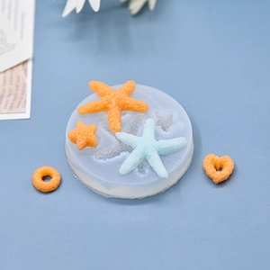 Silicone mold with starfish and heart shapes for baking and DIY crafts on blue background