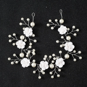 Detailed shot of handmade ceramic roses and pearls on a silver bridal hair comb