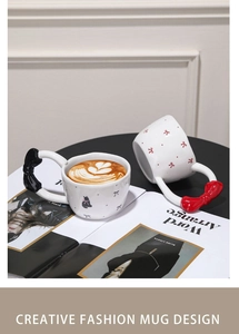 Detailed view of ceramic mug featuring a 3D butterfly handle and cute cat pattern