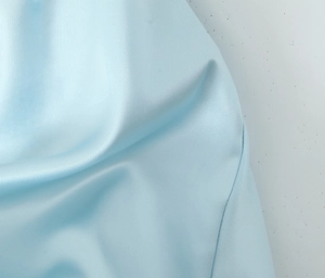 Detailed macro view of the light blue silky satin fabric texture and premium glossy finish
