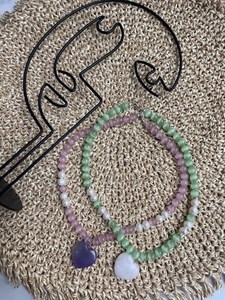 Detail of beaded choker necklaces featuring heart pendants and pastel cat eye stones