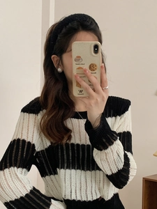 Close-up of a high-quality black and white striped hollow knit sweater on a female model