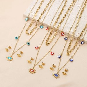 Détails de parures de colliers et boucles d'oreilles œil porte-bonheur dorés et colorés
