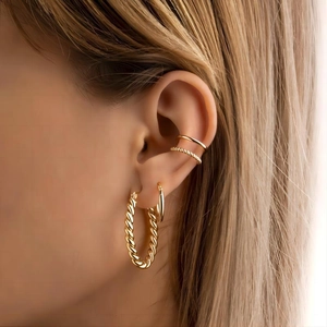 Chic twisted and smooth gold titanium steel hoop earrings set worn by a female model
