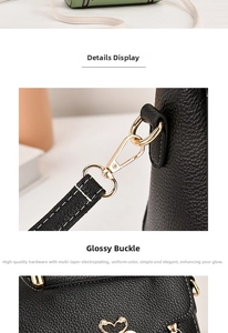 Close-up of black lychee grain leather handbag with gold swan-shaped hardware detail