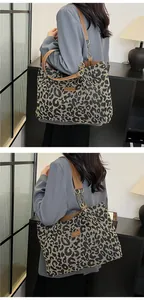 Close-up of leopard print tote bag with brown leather strap and gold chain detail