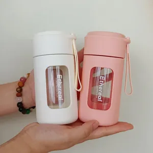 Dual-color portable heat-resistant glass water bottle with silicone sleeve and carrying rope