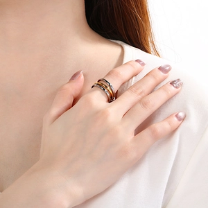 Detail of a multi-layer gold and silver stainless steel ring with pavé diamond accents
