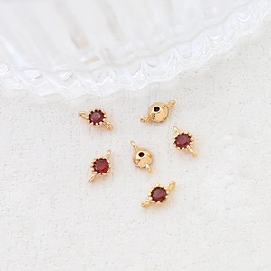 Macro view of gold-plated jewelry connectors with red zircon stones for DIY accessories
