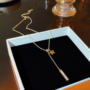 Elegant gold titanium necklace featuring star pendant and rectangle white shell in box