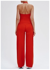 Detail view of red yoga set featuring a backless halter top and high-waisted flared pants