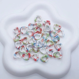 Macro view of ink-washed heart ceramic beads with colorful speckles for DIY jewelry