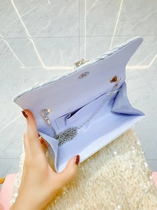 Detail view of silver sequin evening bag with purple lining and silver chain strap