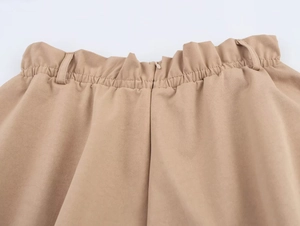 Dettaglio della vita elasticizzata e dei passanti per cintura sui pantaloncini kaki