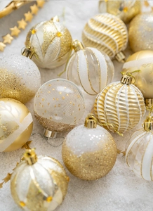 Detailed flat lay of 6cm gold and white Christmas ornaments with glitter and matte finishes