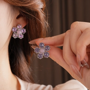 Gros plan sur les boucles d'oreilles fleurs vintage avec pierres violettes et roses