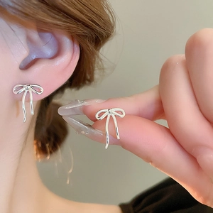 Vue détaillée de clous d'oreilles nœuds argentés avec finition métallique élégante