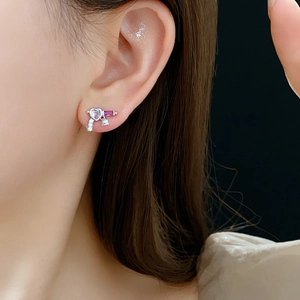Close-up of heart and rectangle zircon stones on silver key-shaped drop earring