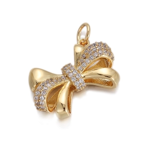 Macro shot of gold bow pendant with sparkling clear zircons and connector loop
