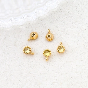 Macro shot of 18K gold plated charms with light green zircon stones for DIY jewelry making