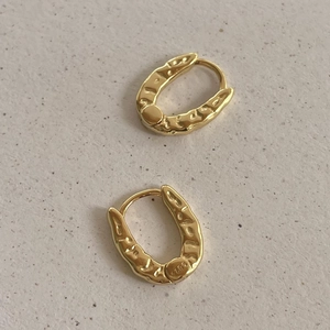 Irregular textured gold S925 sterling silver hoop earrings on a minimalist background