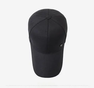 Top-down view of black cotton twill baseball cap with extended brim and side logo