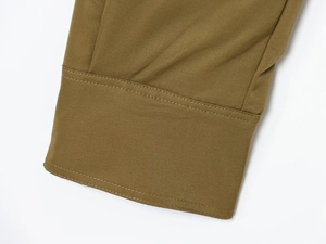 Macro shot of olive green woven sleeve cuffs with detailed double-stitched craftsmanship