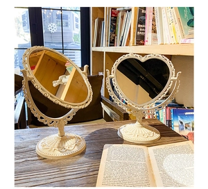 Detail of vintage heart and oval vanity mirrors with ornate cream embossed frames