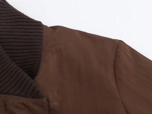 Close-up of ribbed collar and shoulder stitching on a brown fashion jacket