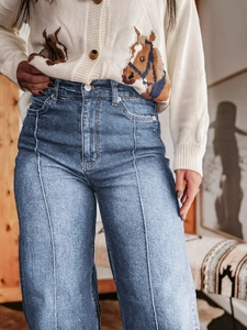 Detail van een blauwe jeans met hoge taille, vintage lengtenaad en stikselaccenten