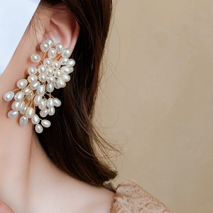 Détail de boucles d'oreilles vintage en perles tissées style baroque français sur modèle
