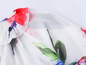 Détail du chemisier en mousseline à fleurs avec col à volants et imprimés rouges