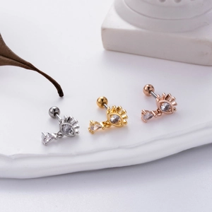 Macro detail of devil eye helix earrings with zircon teardrop in gold and silver