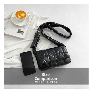 Detailed view of black puffer crossbody bag featuring quilted lattice pattern and adjustable strap