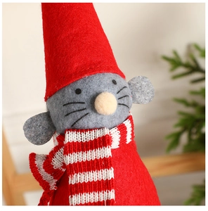 Gros plan d'une poupée ange de Noël avec un chapeau rouge pointu et une écharpe rayée