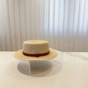 Detailed view of the fine straw weave and brown leather band on the flat top boater hat