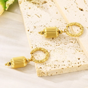 Dettaglio di orecchini a lanterna placcati oro 18K con sfera in metallo testurizzato