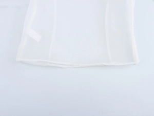 Close-up of white organza top hem showing fine mesh texture and blank sewing label