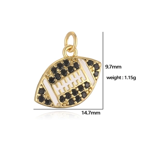Close-up of golden shell pendant with black gemstones and white enamel, 14.7x9.7mm