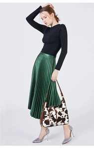 Fashionable cow print shoulder bag worn by model with brown strap detail